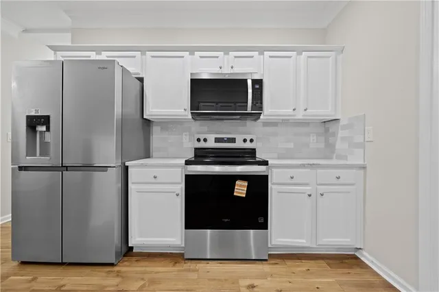 a kitchen with a refrigerator and a stove top oven