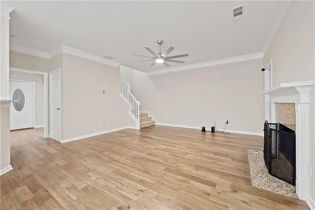 a view of empty room with fireplace and wooden floor