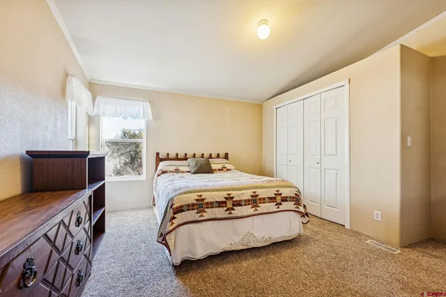 a bedroom with a bed and large window