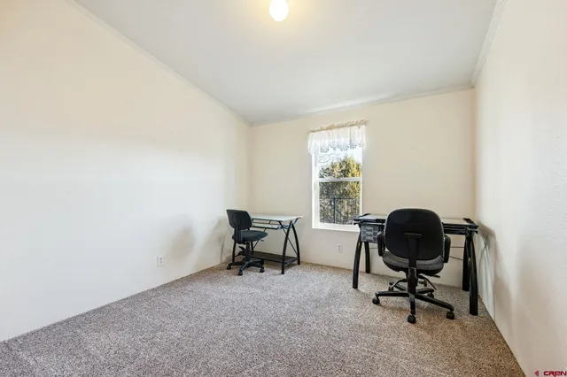 a view of a workspace with furniture and a window