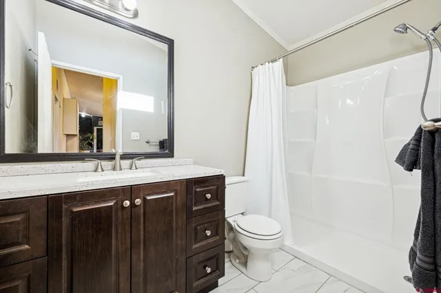a bathroom with a granite countertop sink toilet and shower
