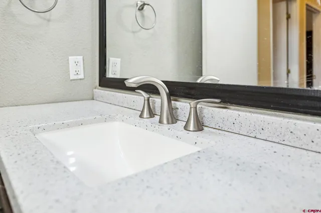a close view of a faucet a sink and a mirror in a bathroom