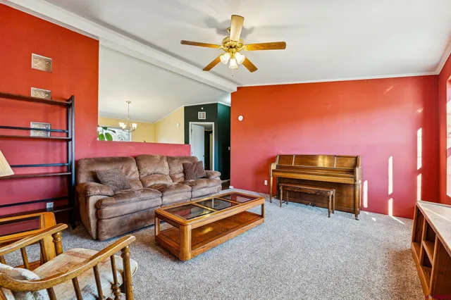 a living room with furniture a ceiling fan and a window