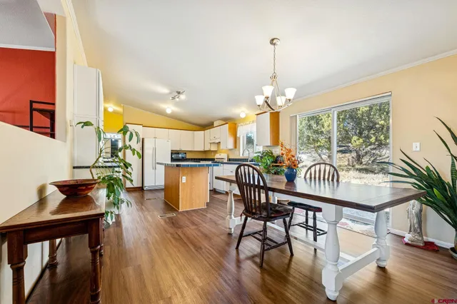 a dining room with furniture a chandelier and wooden floor