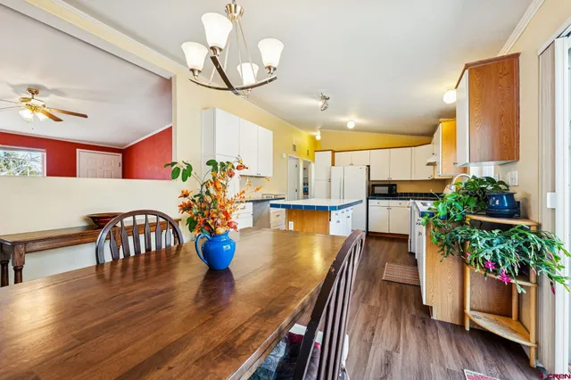 a dining room with furniture potted plants and wooden floor