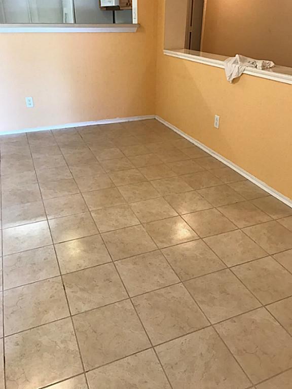 3142 Aspen Fair Trail Spring, TX 77389 - Photo 6 of 22 This room features a clean, tiled floor with light, neutral tones. The walls are painted in a warm color, and a partial wall separates the space, providing an open view to the adjoining area.