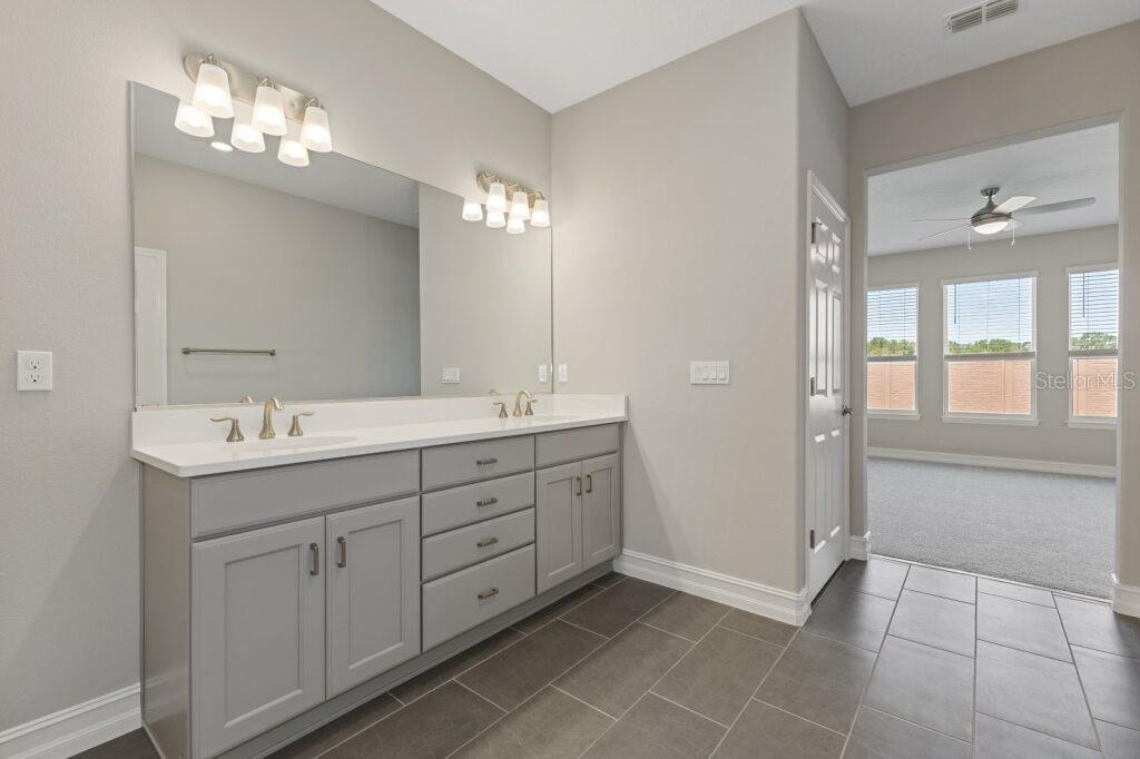 5567 Northwest 45th Lane Ocala, FL 34482 - Photo 15 of 21 a bathroom with a double vanity sink a mirror and a shower