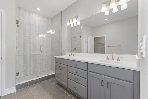 a bathroom with a double vanity sink mirror and shower