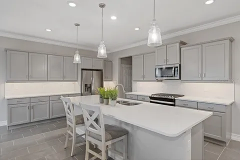 a kitchen with a table a refrigerator a cabinets and chairs