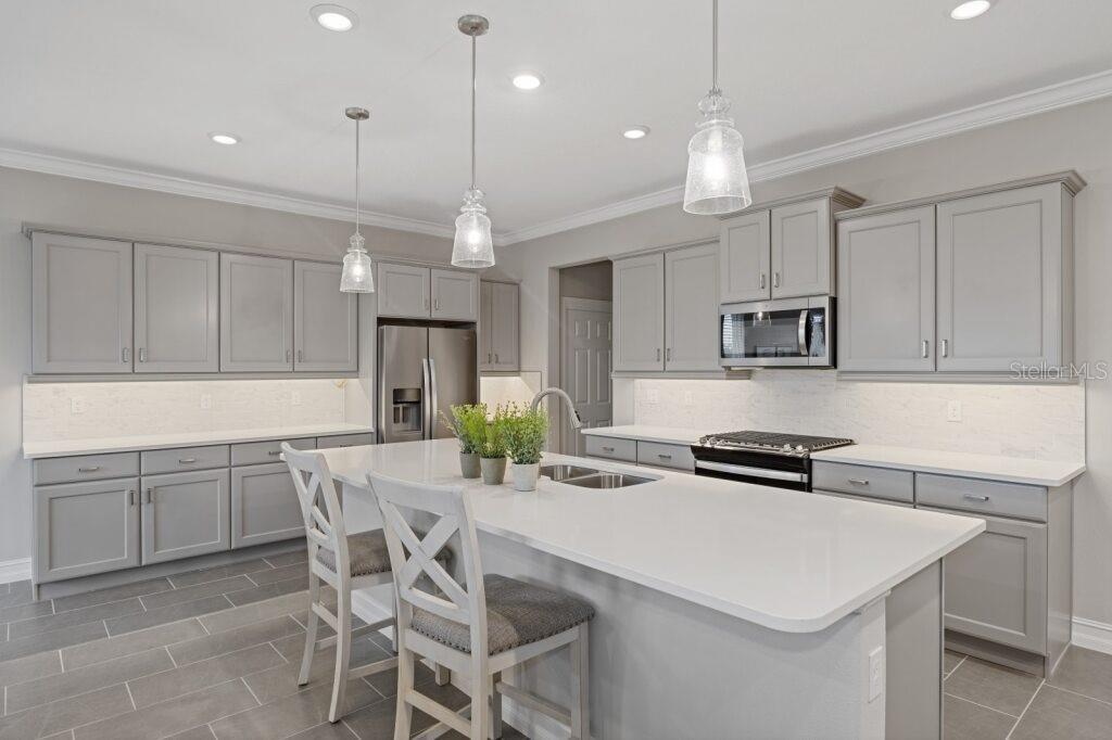 5567 Northwest 45th Lane Ocala, FL 34482 - Photo 4 of 21 a kitchen with a table a refrigerator a cabinets and chairs