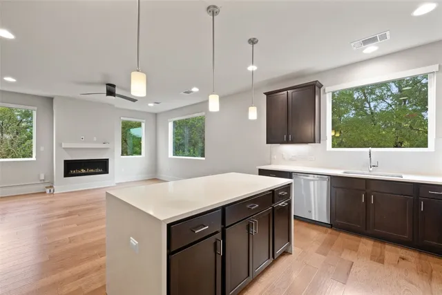 a kitchen with a stove sink and a fireplace with wooden floor
