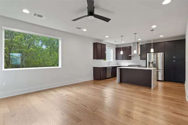 a large kitchen with kitchen island a large counter top space appliances and cabinets