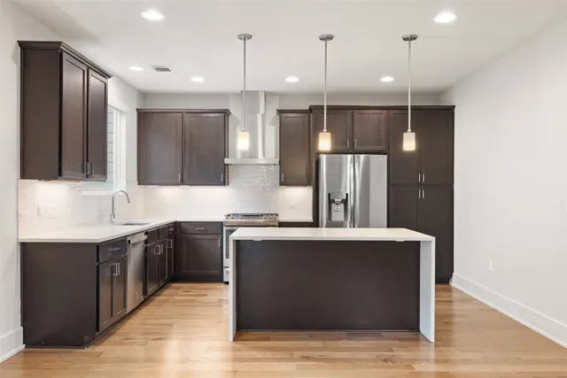 a kitchen with stainless steel appliances granite countertop a sink a stove and a refrigerator