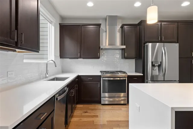a kitchen with stainless steel appliances a sink stove and refrigerator