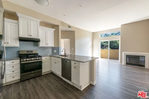 a kitchen with stainless steel appliances granite countertop a stove a sink and a refrigerator