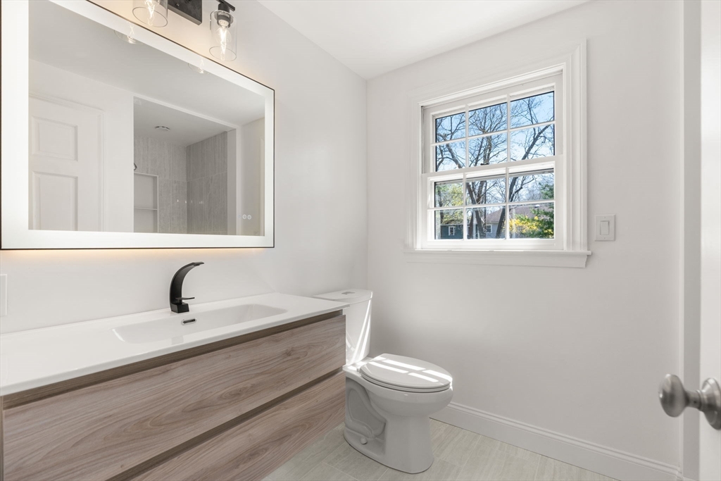 30 Ivy Road Wellesley, MA 02482 - Photo 19 of 34 a bathroom with a toilet a sink a mirror and window