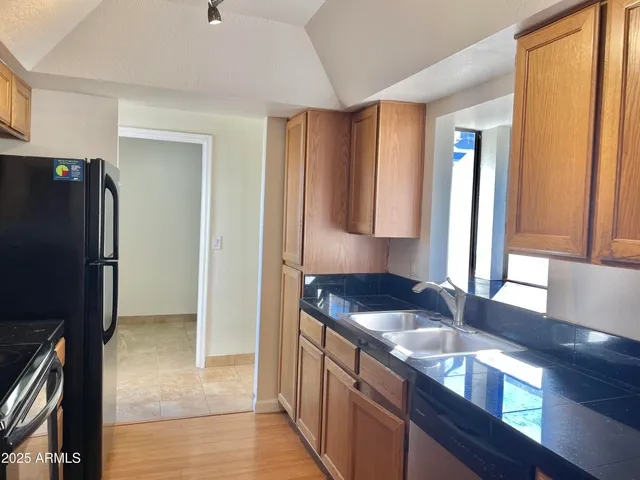 a kitchen with granite countertop a refrigerator and a sink