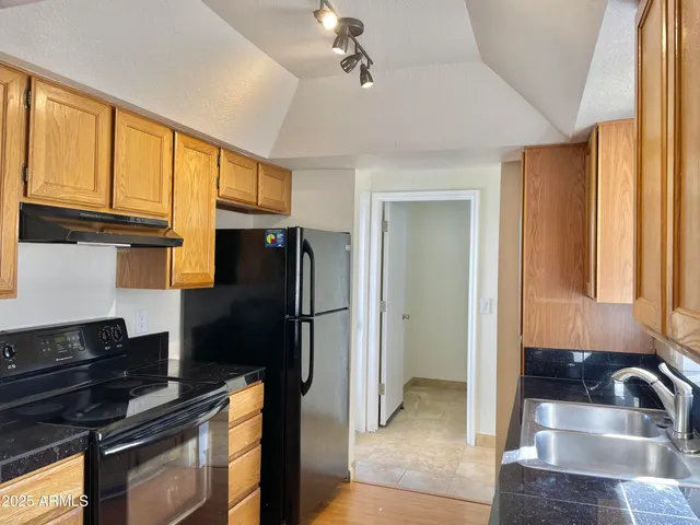 a kitchen with granite countertop a refrigerator and a sink