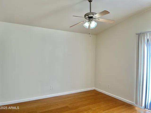 a view of a room with wooden floor and chandelier fan