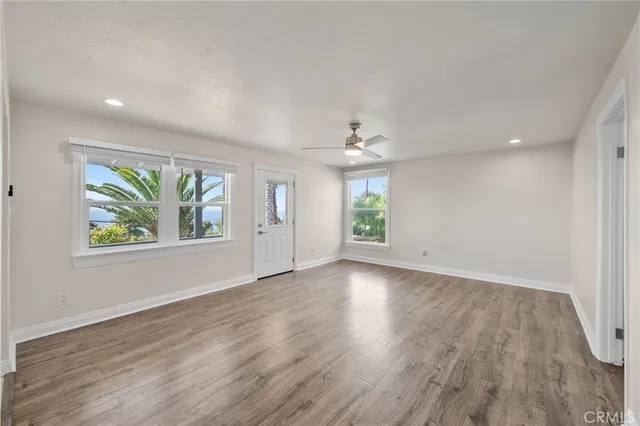 an empty room with window and wooden floor