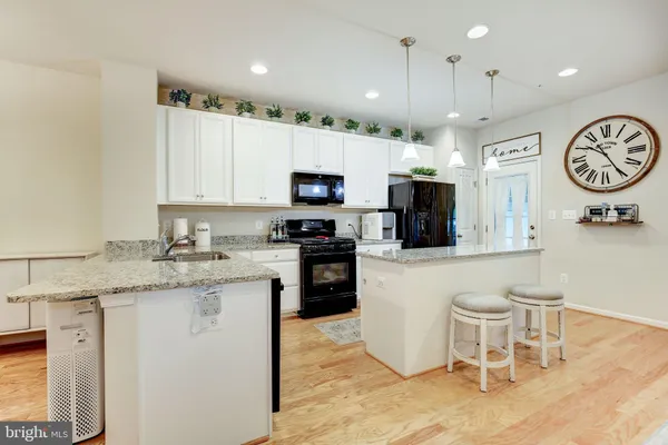 a view of a kitchen with fridge and wooden floor