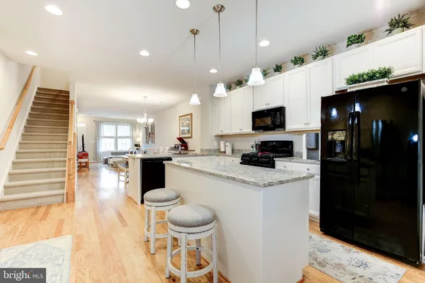 a kitchen with a refrigerator a stove top oven a clock and a window