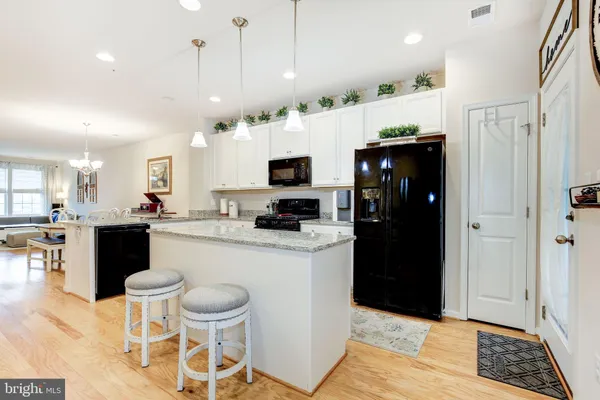 a kitchen with a dining table chairs and a refrigerator