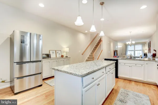a kitchen with stainless steel appliances granite countertop a sink a refrigerator and a stove
