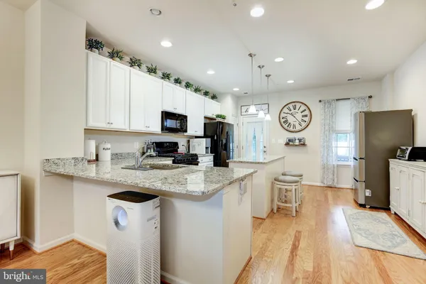 a kitchen with a sink a counter top space stainless steel appliances cabinets and a window
