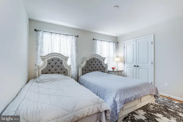a bedroom with two beds and large windows