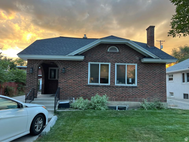 433 North 300 East Provo, UT 84606 - Photo 1 of 1 View of front of house featuring a chimney, brick siding, a yard, and a shingled roof