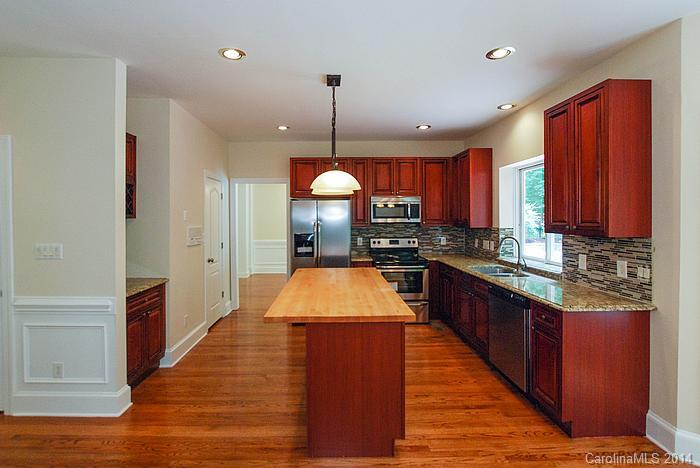7131 Forest Ridge Road Weddington, NC 28104 - Photo 11 of 23 a kitchen with stainless steel appliances granite countertop wooden floors wooden cabinets a sink and a oven