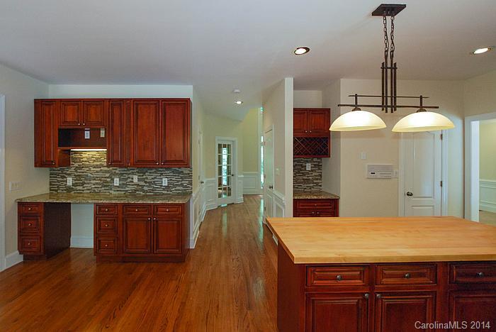 7131 Forest Ridge Road Weddington, NC 28104 - Photo 12 of 23 a kitchen with kitchen island granite countertop wooden cabinets and a stove