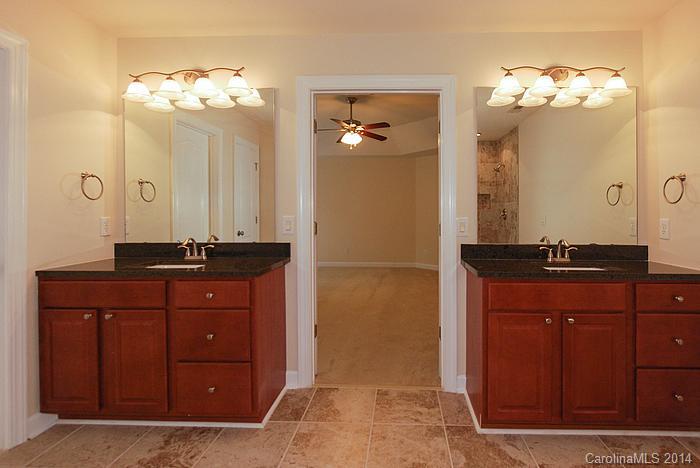 7131 Forest Ridge Road Weddington, NC 28104 - Photo 17 of 23 a bathroom with a granite countertop sink a mirror and a shower