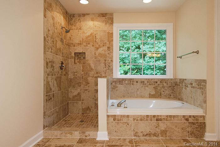 7131 Forest Ridge Road Weddington, NC 28104 - Photo 18 of 23 a bathroom with a granite countertop bathtub and shower