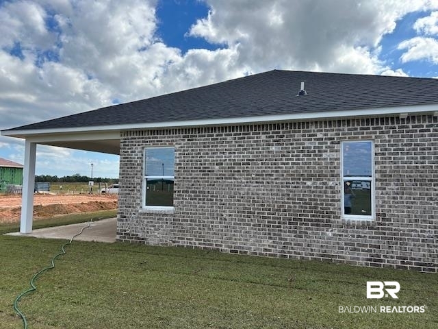 18127 Kent Circle Foley, AL 36535 - Photo 8 of 8 View of property exterior featuring brick siding, a patio, and a lawn