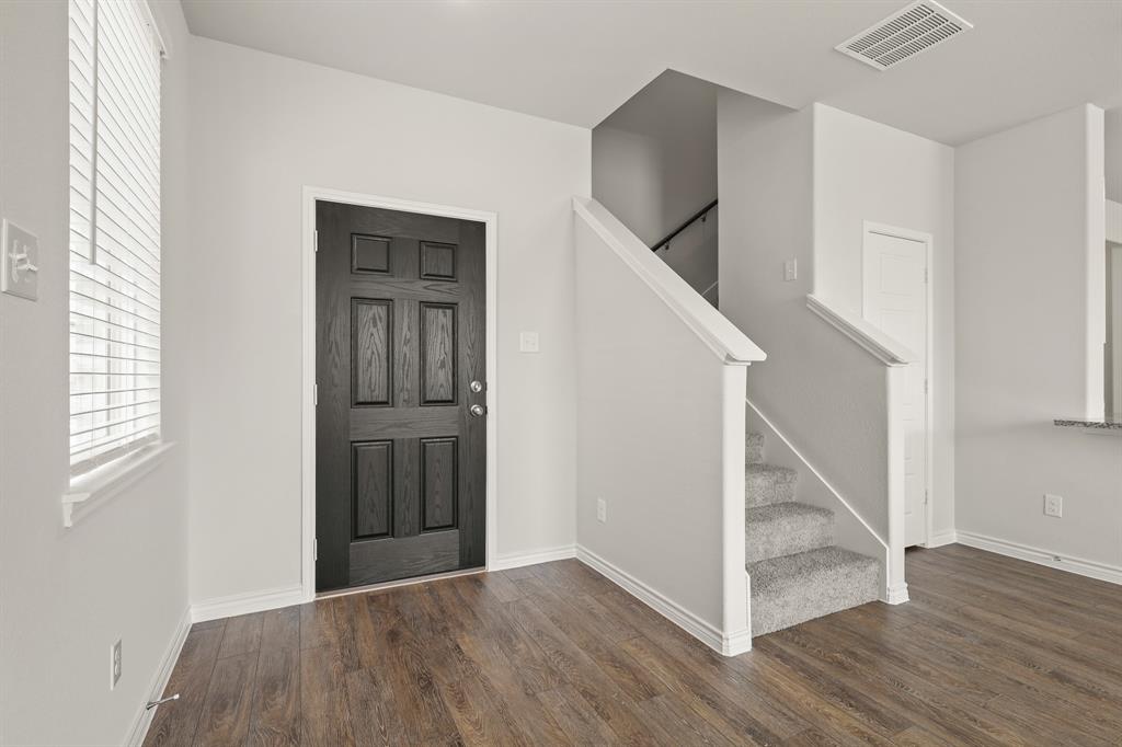 1511 Romans Road Ennis, TX 75119 - Photo 4 of 22 a view of an entryway with wooden floor and door