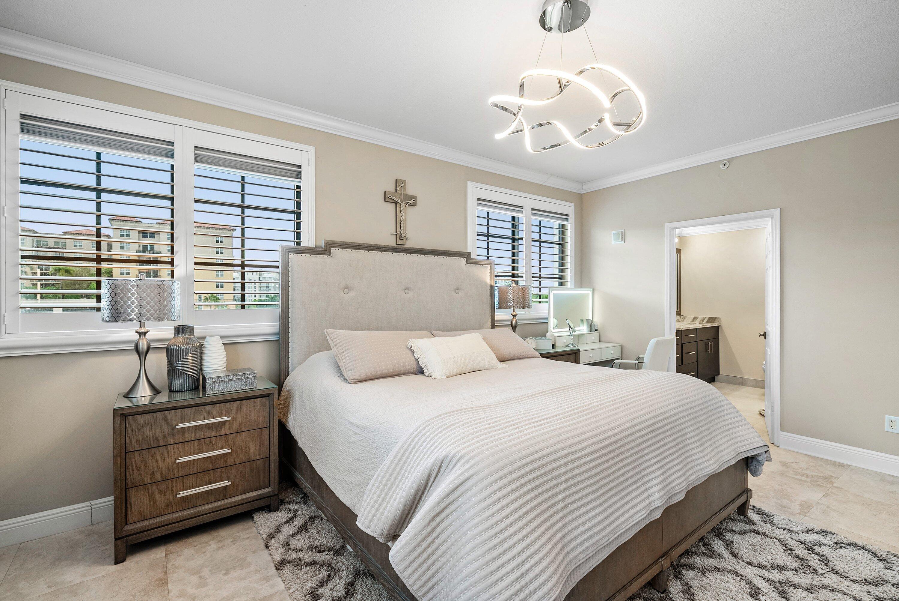 233 South Federal Highway, Unit 509 Boca Raton, FL 33432 - Photo 19 of 49 a bedroom with a large bed and a chandelier