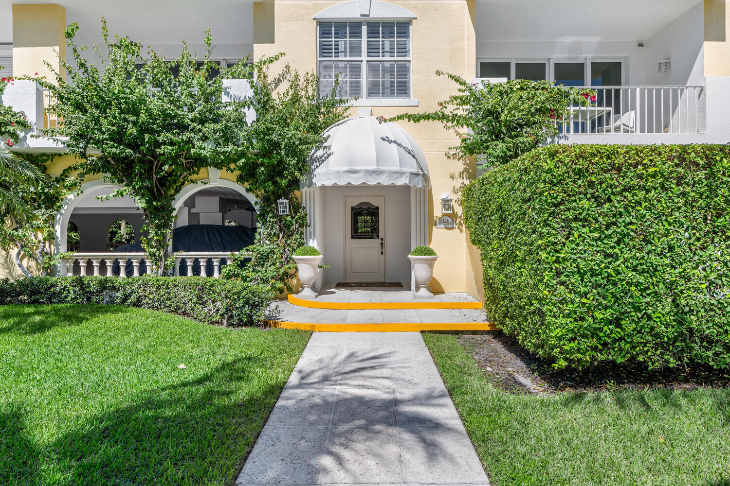 127 Peruvian Avenue, Unit 302 Palm Beach, FL 33480 - Photo 1 of 52 a front view of a house with a yard and potted plants