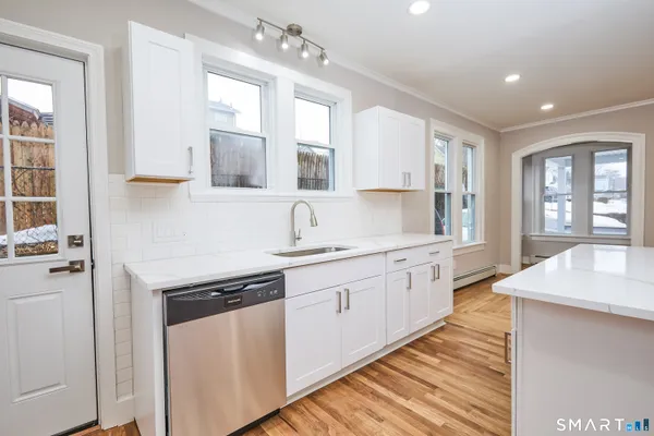a kitchen with kitchen island a white counter top space and cabinets