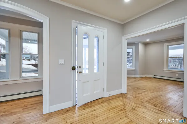 a view of a hallway with wooden floor and staircase