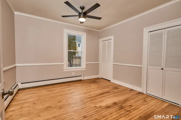 a view of a room with wooden floor and a window
