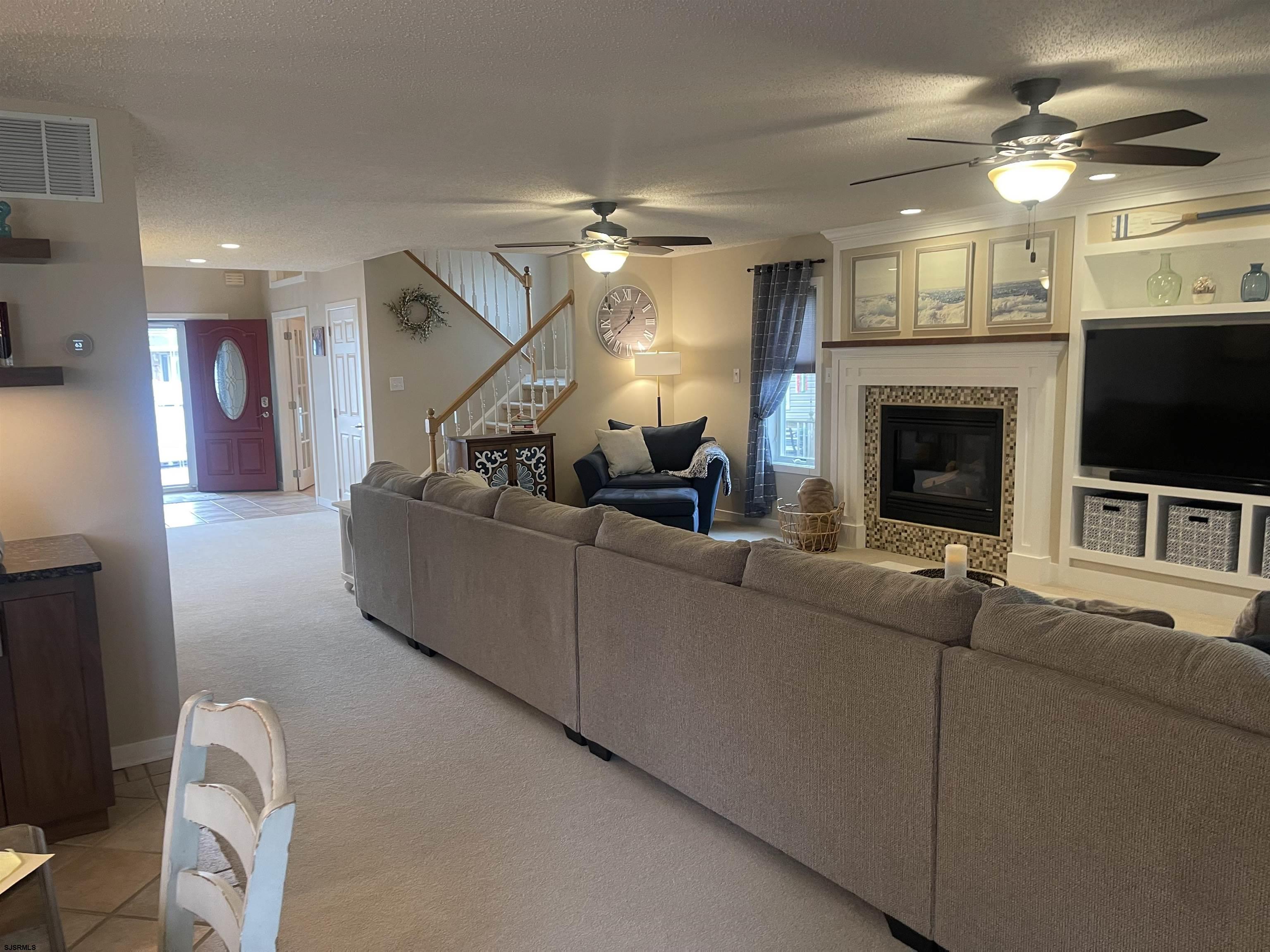 16 Collette Circle Brigantine, NJ 08203 - Photo 13 of 13 a living room with furniture a fireplace and a flat screen tv