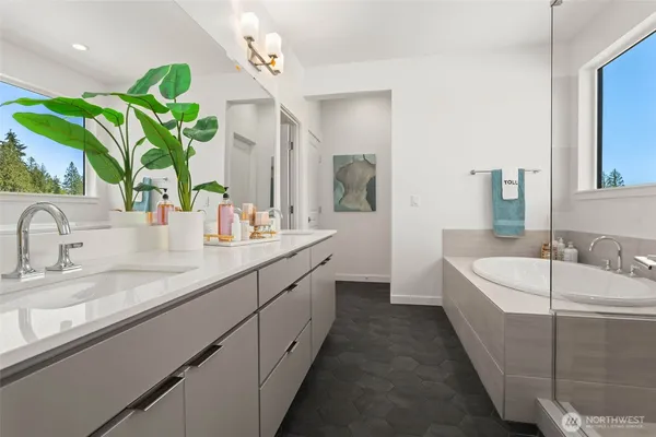 a spacious bathroom with a double vanity sink a mirror a bathtub and vanity