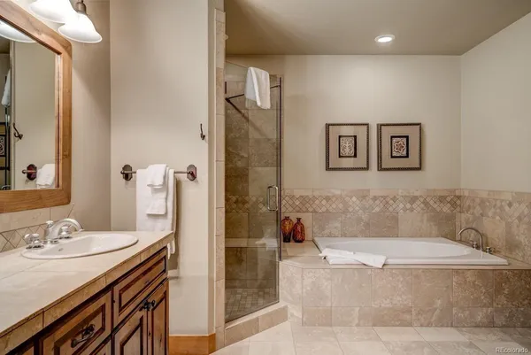 a bathroom with a granite countertop tub sink and mirror