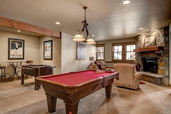 a room with furniture pool table flat screen tv and windows