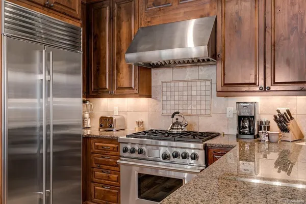 a kitchen with stainless steel appliances granite countertop a stove and a refrigerator