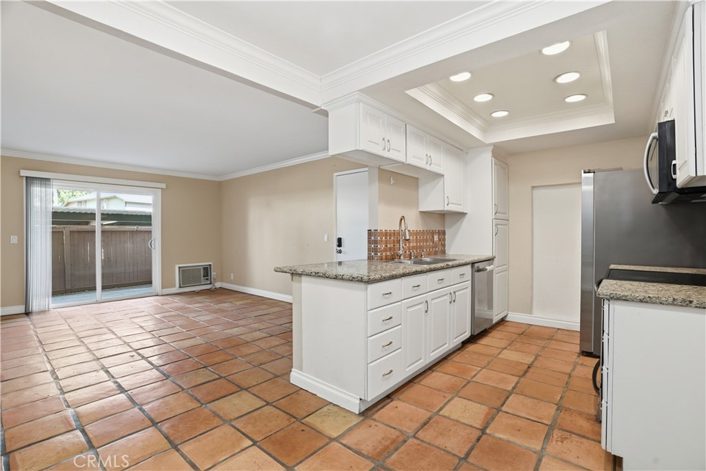 20702 El Toro Road, Unit 231 Lake Forest, CA 92630 - Photo 22 of 36 a kitchen with granite countertop a sink and a stove top oven