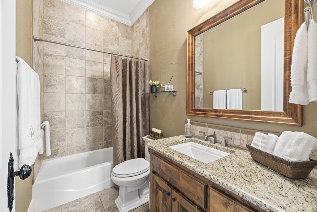 150 St Andrews Loop Kerrville, TX 78028 - Photo 14 of 27 a bathroom with a granite countertop sink toilet and shower