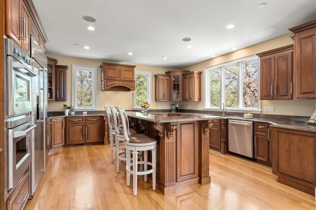 74 Carter Drive Framingham, MA 01701 - Photo 8 of 23 a kitchen with stainless steel appliances granite countertop a stove a sink dishwasher a microwave oven and a dining table with wooden floor